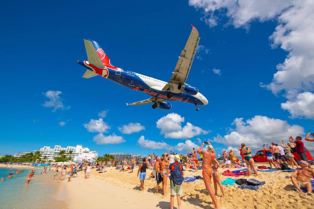Airplane flying over Maho Beach during the Full-Day Island Tour in St. Maarten.